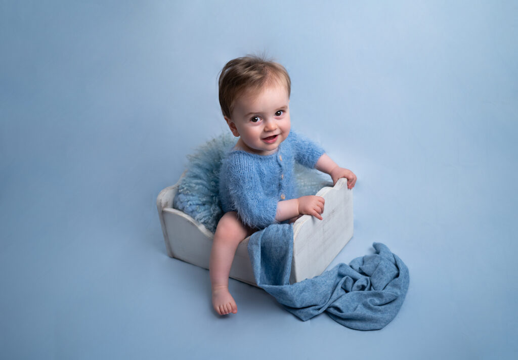 bébé dans une caisse décor bleu sourire photographe bébé Houilles photographe bébé la Défense photographe bébé Yvelines