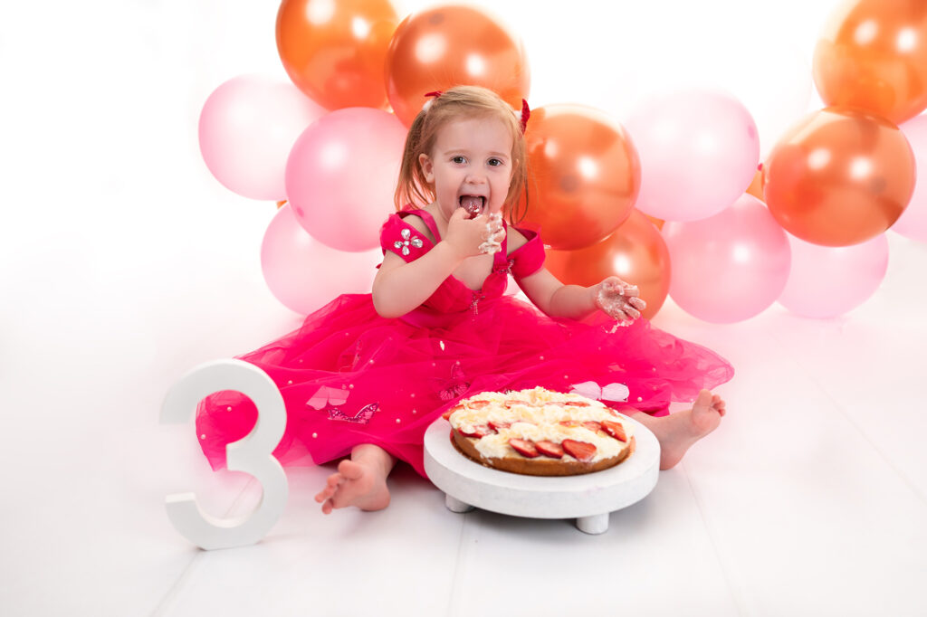 Petite fille de trois ans ballons sur fond blanc photographe enfants Houilles shooting enfants Houilles photographe enfants Yvelines shooting enfants Yvelines