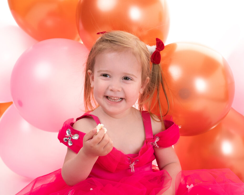 Petite fille de trois ans ballons sur fond blanc photographe enfants Houilles shooting enfants Houilles photographe enfants Yvelines shooting enfants Yvelines