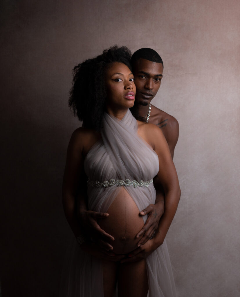 Couple de futurs parents sur fond blanc shooting grossesse Houilles photographe grossesse Houilles photographe grossesse Yvelines 