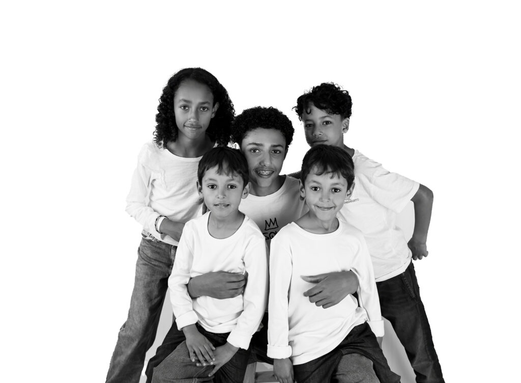 Photo en noir et blanc de frères et soeurs sur fond blanc photographe enfants Houilles photographe enfants Yvelines séance photo enfant Houilles