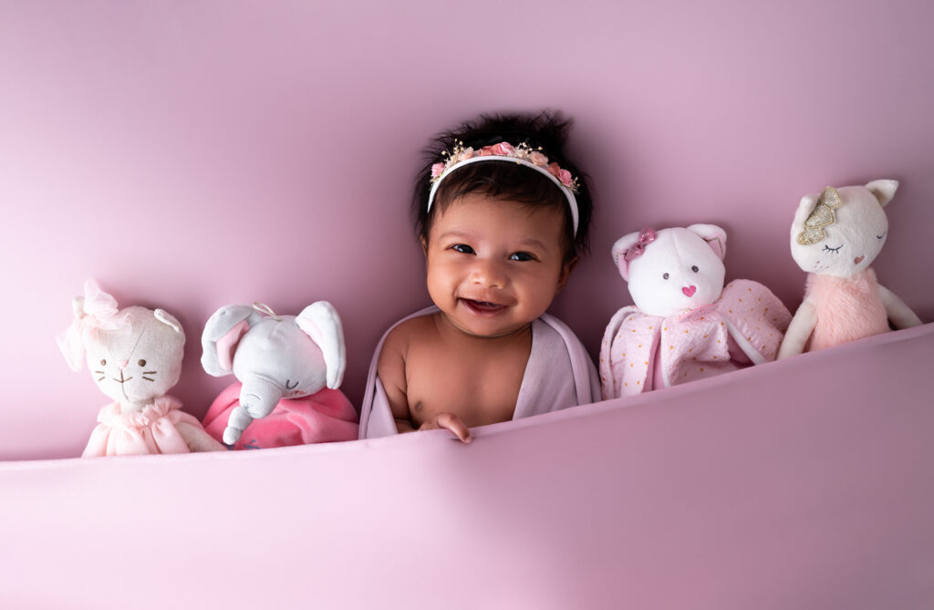 bébé sur fond rose grand sourire photographe bébé Houilles photographe bébé la Défense photographe bébé Yvelines