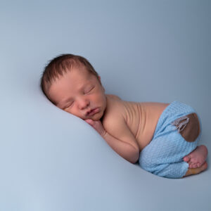 nouveau-né endormi sur fond bleu sourire photographe naissance Houilles photographe naissance la Défense photographe Houilles photographe Versailles photographe Rueil-Malmaison photographe Chatou photographe Yvelines photographe Ile-de-France photographe naissance Yvelines photographe nouveau-né Yvelines photographe bébé Yvelines