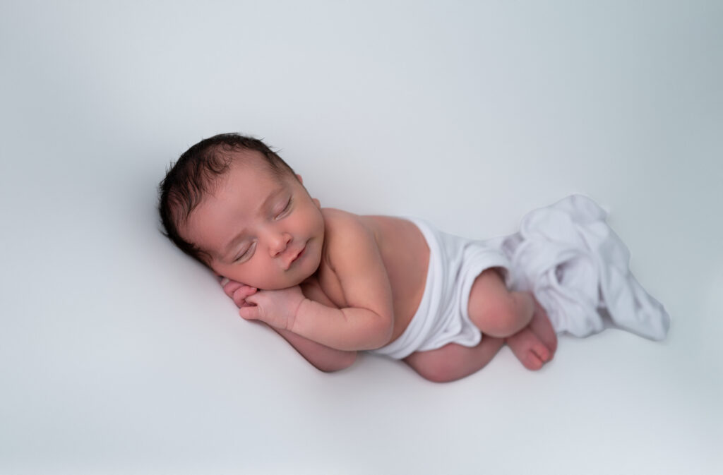 nouveau-né endormi sur fond blanc uni photographe naissance Houilles photographe naissance la Défense photographe Houilles photographe Versailles photographe Rueil-Malmaison photographe Chatou photographe Yvelines photographe Ile-de-France