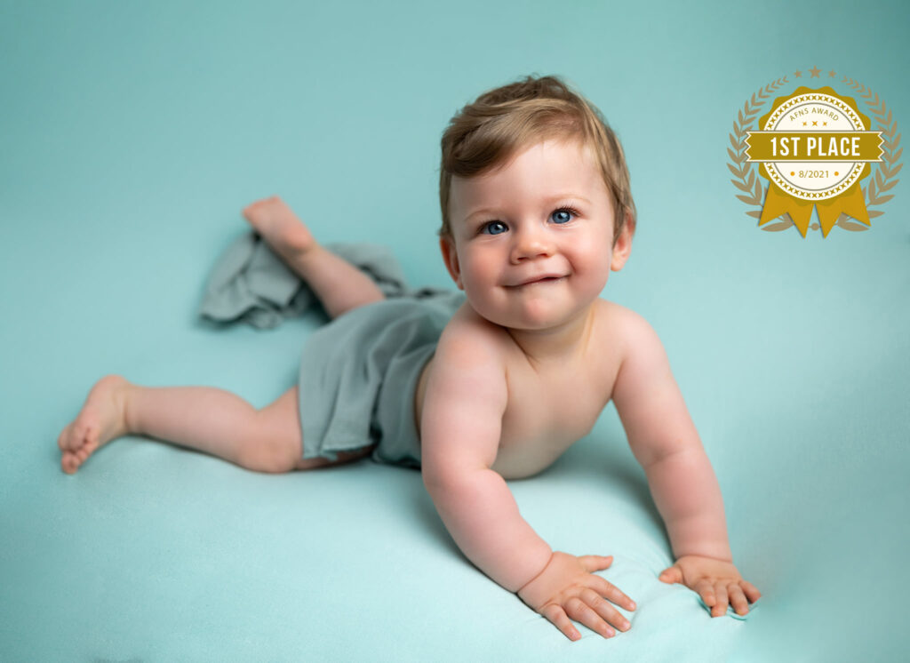 bébé sur fond vert sourire médaille d'or AFNS photographe bébé Houilles photographe bébé la Défense photographe bébé Yvelines