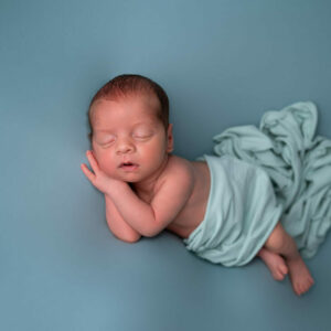 nouveau-né endormi sur fond bleu sourire photographe naissance Houilles photographe naissance la Défense photographe Houilles photographe Versailles photographe Rueil-Malmaison photographe Chatou photographe Yvelines photographe Ile-de-France photographe naissance Yvelines photographe nouveau-né Yvelines photographe bébé Yvelines