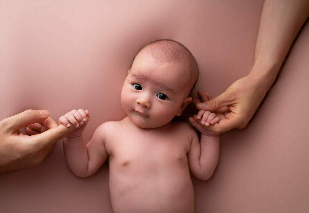bébé qui tient les mains de ses parents photographe naissance Houilles photographe naissance la Défense photographe Houilles photographe Versailles photographe Rueil-Malmaison photographe Chatou photographe Yvelines photographe Ile-de-France