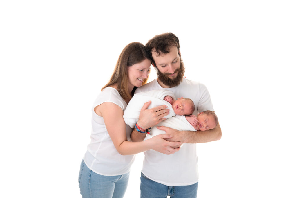 Jumeaux endormis dans les bras de leurs parents séance photo naissance Houilles Yvelines shooting naissance Houilles Yvelines photographe naissance Houilles Yvelines