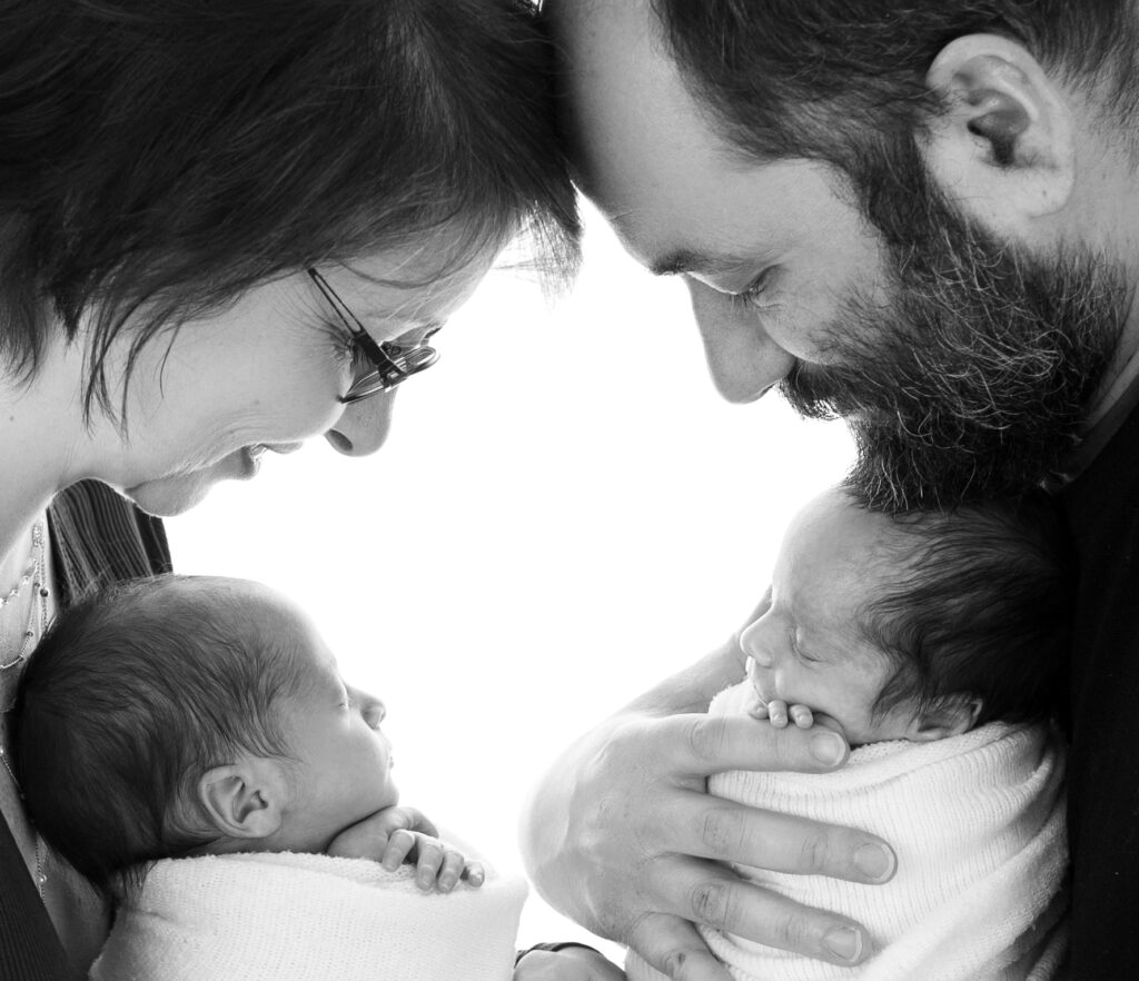 Jumeaux endormis dans les bras de leurs parents séance photo naissance Houilles Yvelines shooting naissance Houilles Yvelines photographe naissance Houilles Yvelines
