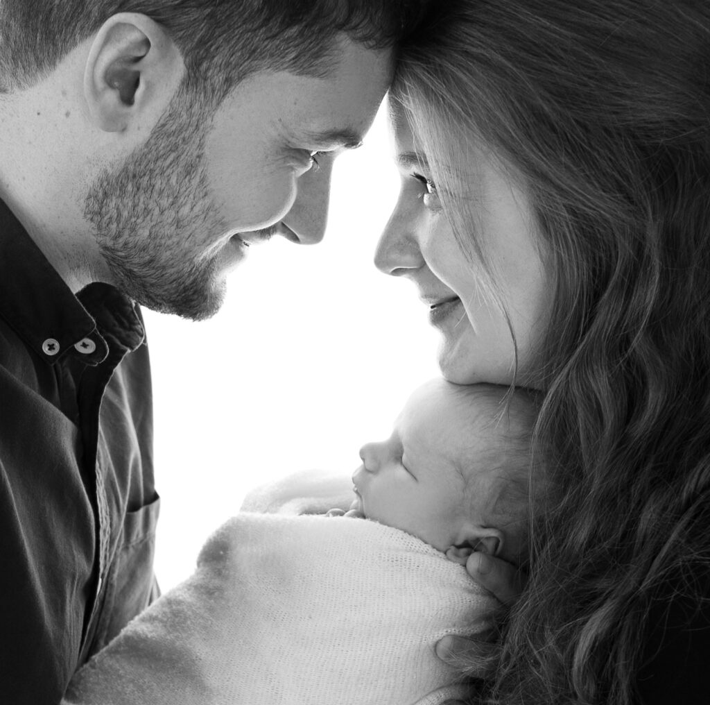 Parents tenant leur nouveau-né dans les bras profils les coulisses d'une séance photo photographe Houilles photographe nouveau-né Houilles photographe naissance Houilles photographe naissance Yvelines photographe naissance Ile de France photographe naissance Paris